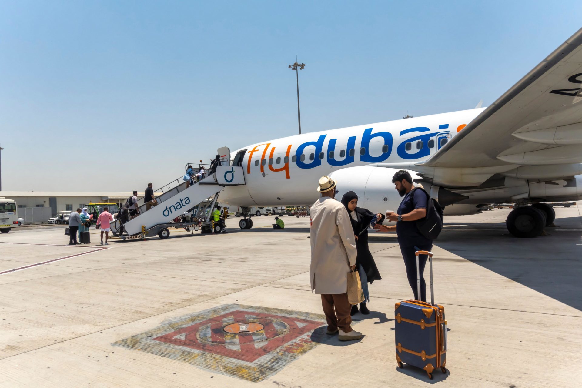 2RMC4KD Passengers boarding airstairs to FlyDubai aircraft in Dubai Airport, UAE