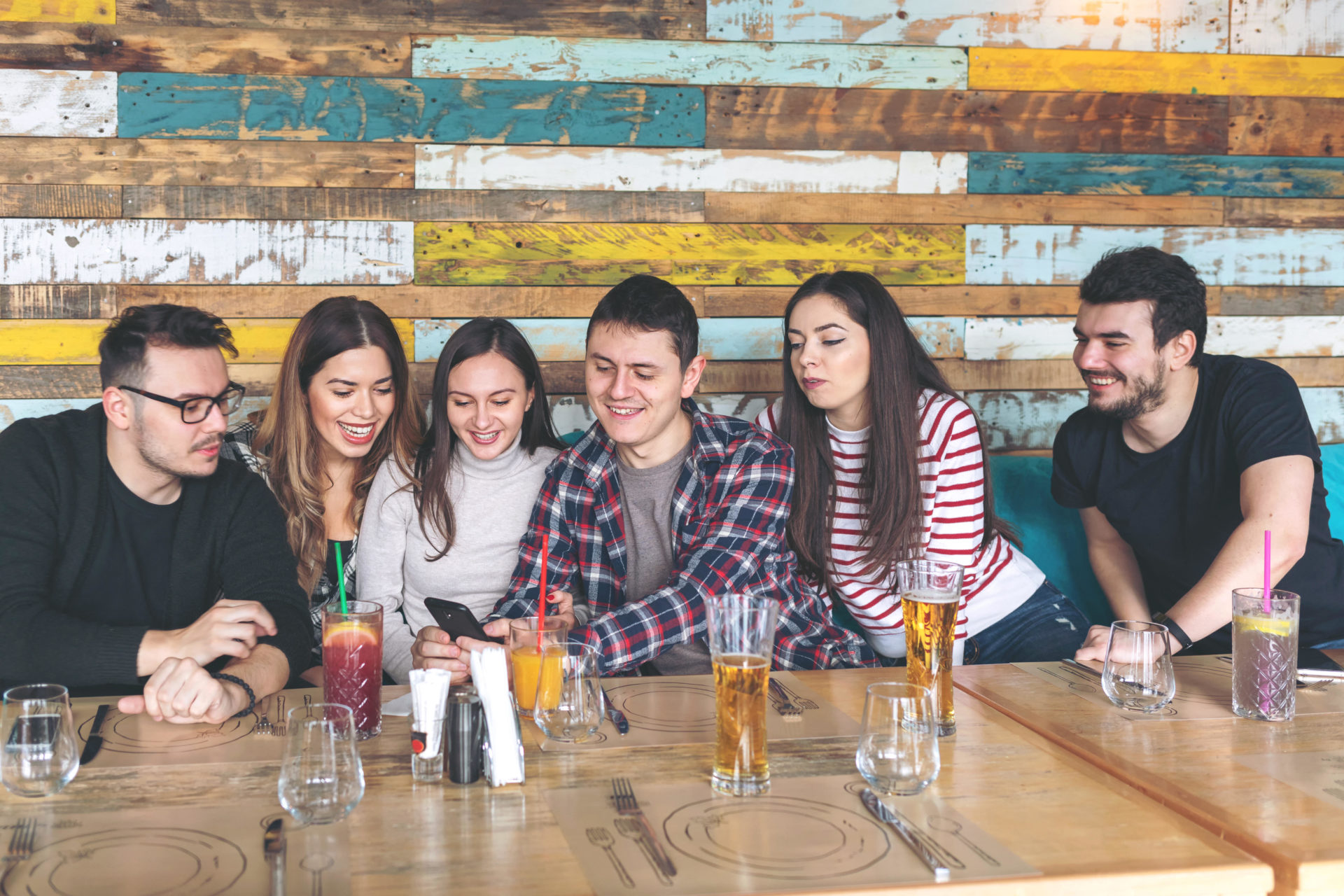 WP5D0B Group of best friends watching videos on smartphone at modern pub