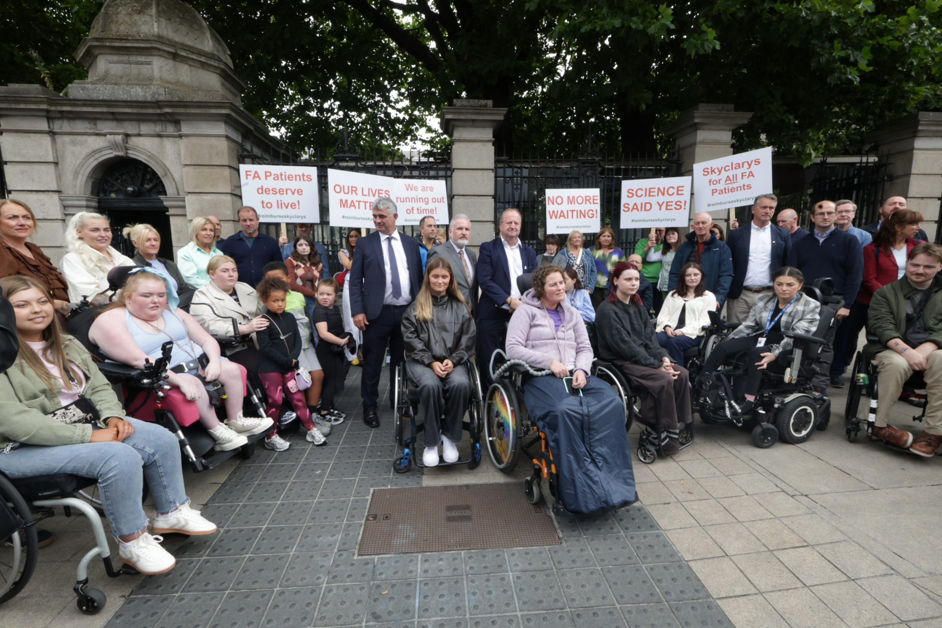 20/08/2026 Dublin Irish leinster Ireland. Photo shows councillor Ken O'Flynn with Independent TD's Richard O'Donoghue and Michael Collins with protesters at the Friedreich's Ataxia protest outside the Dail (Leinster House). On August 11, the HSE drugs group did not recommend the drug for reimbursement, largely based on a review by the National Centre for Pharmacoeconomics (NCPE). The maker of the FriedreichÕs ataxia drug Skyclarys have disputed figures cited by the HSE for the public reimbursement of the drug, as a crunch decision on the drugÕs availability looms. Photo: Leah Farrell/© RollingNews.ie